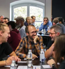 Groupe de collaborateurs échangeant autour d'une table.